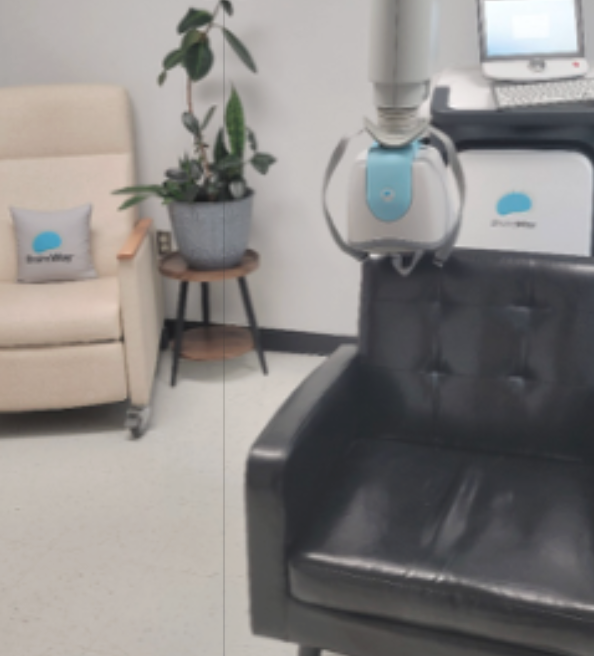 Transcranial Magnetic Stimulation (TMS) treatment chair and equipment in a clinical behavioral health treatment room.